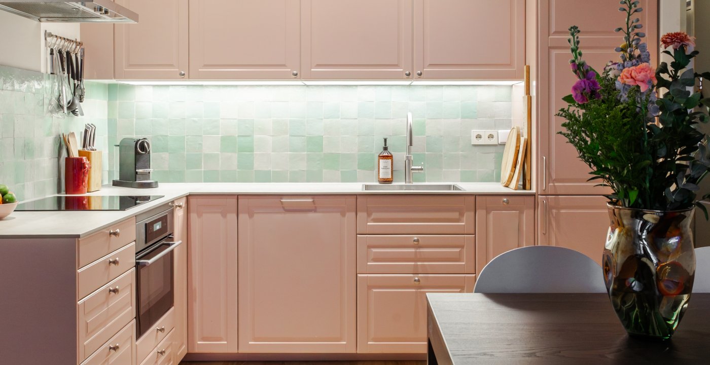 Interieurontwerp met roze L-keuken, zwarte eettafel en saliegroene zellige-tegels, door cestsjoukje