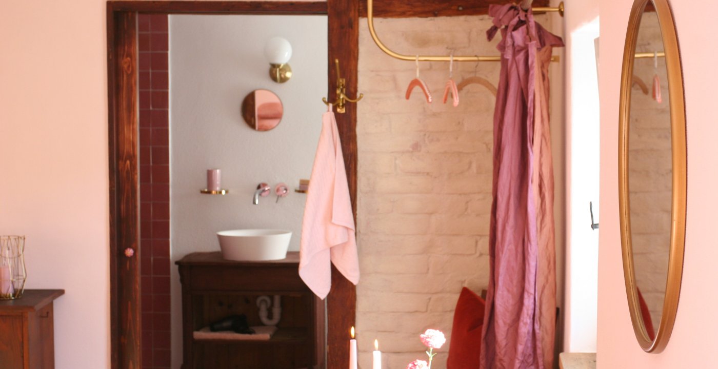 Boutique hotelkamer met roze accenten en ronde spiegel, door cestsjoukje