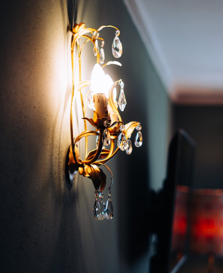 Antieke messing wandlamp als sfeerdetail, boutique hotel interieur door cestsjoukje