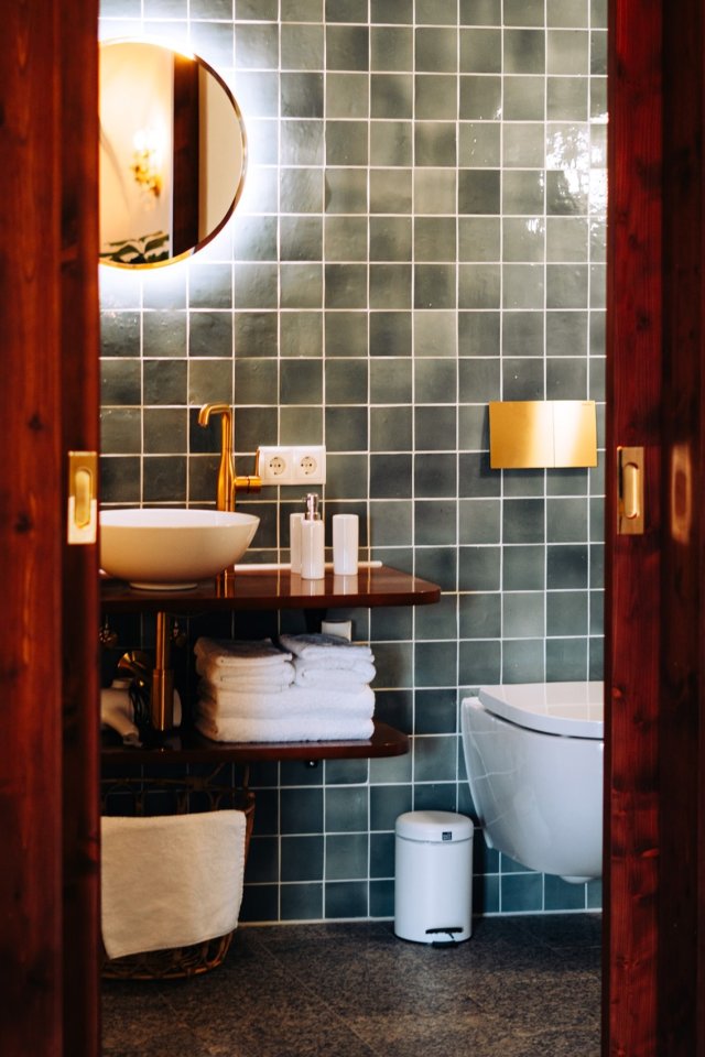 Hotelbadkamer met zachte groene tegels, door cestsjoukje