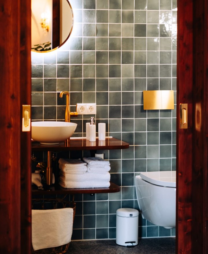 Hotelbadkamer met zachte groene tegels, door cestsjoukje