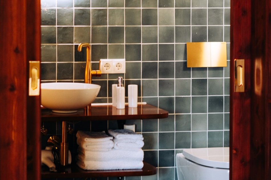Hotelbadkamer met zachte groene tegels, door cestsjoukje