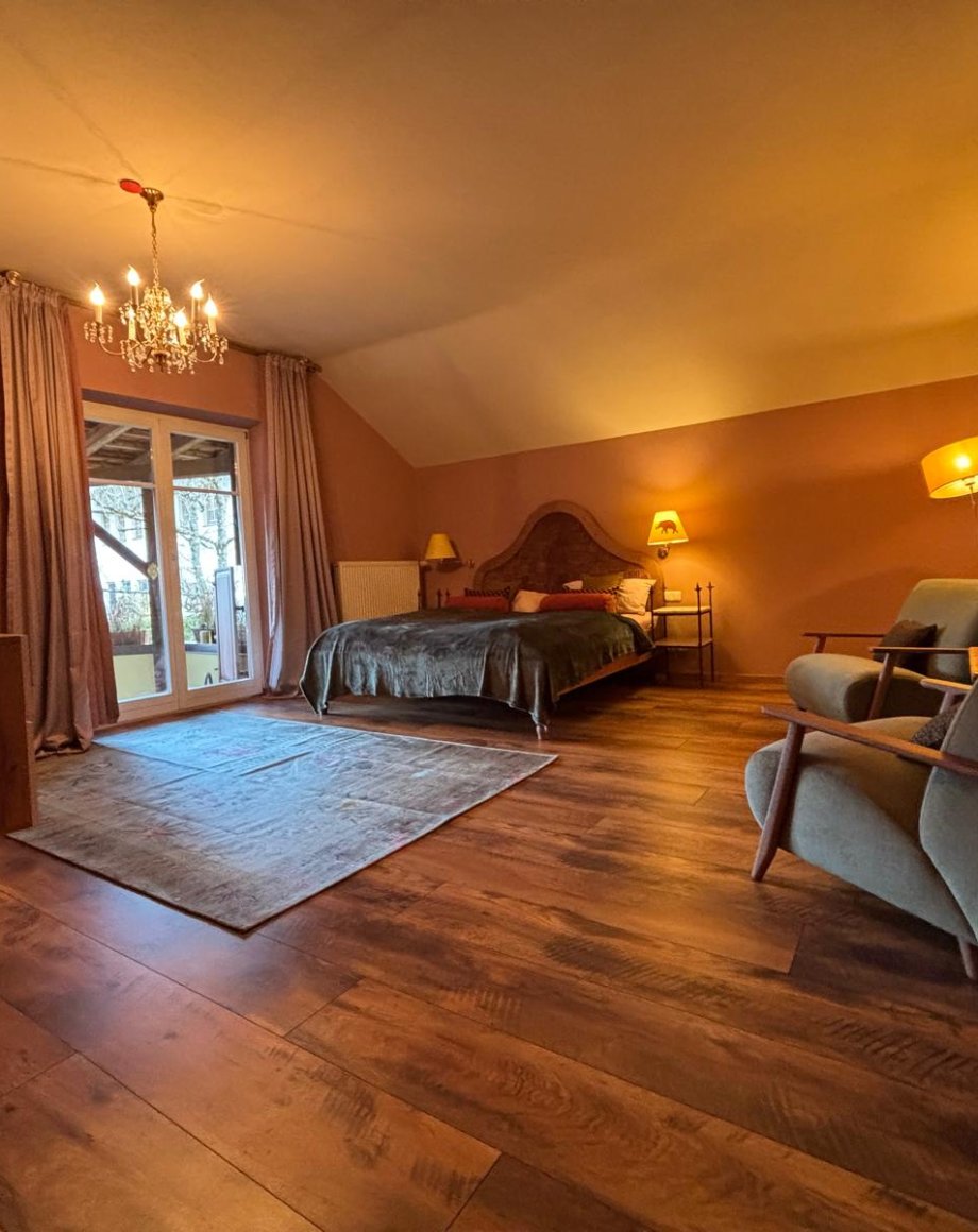 Woonkamer in een vakantieappartement met kroonluchter, houten vloer en warme rosatinten, door cestsjoukje