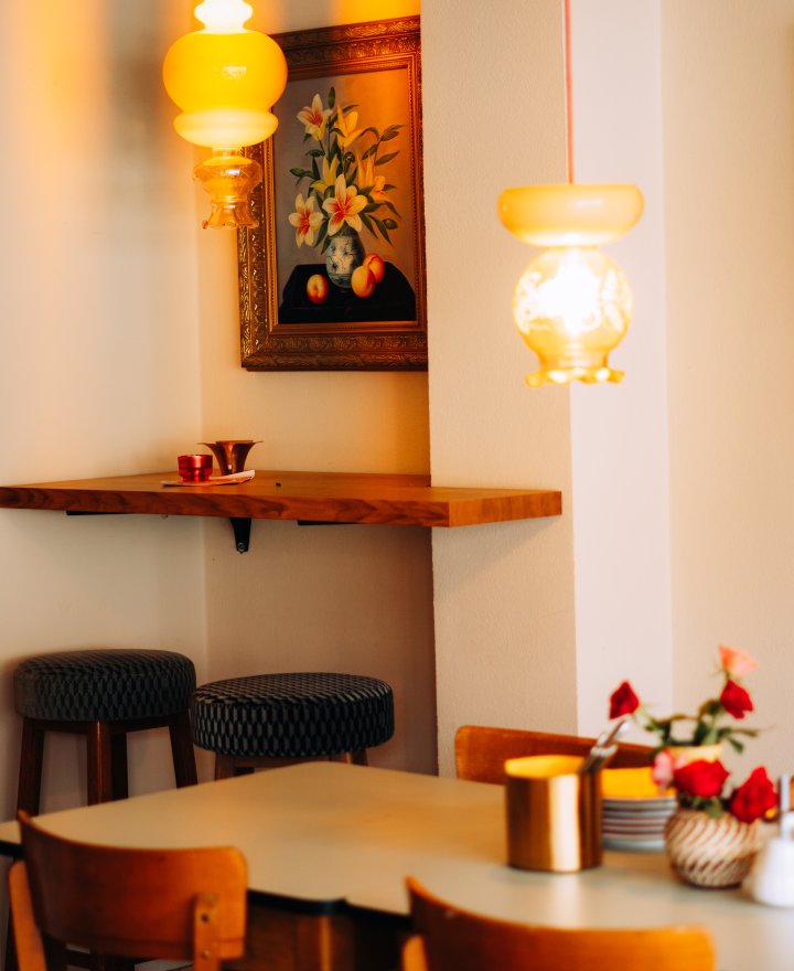 Cafe-interieur met gele glazen hanglampen boven de tafels, door cestsjoukje