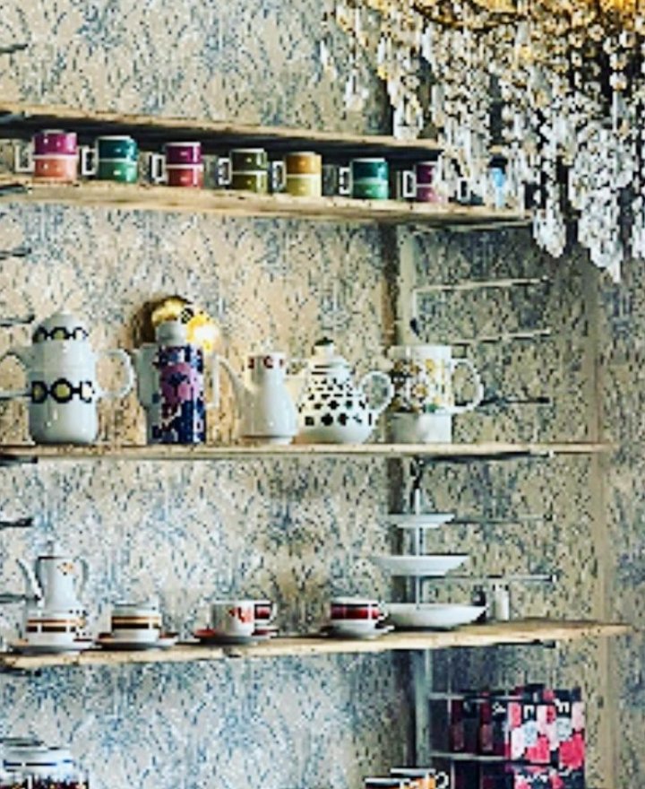Cafe-interieur met vitrinekast vol bont vintage servies, door cestsjoukje