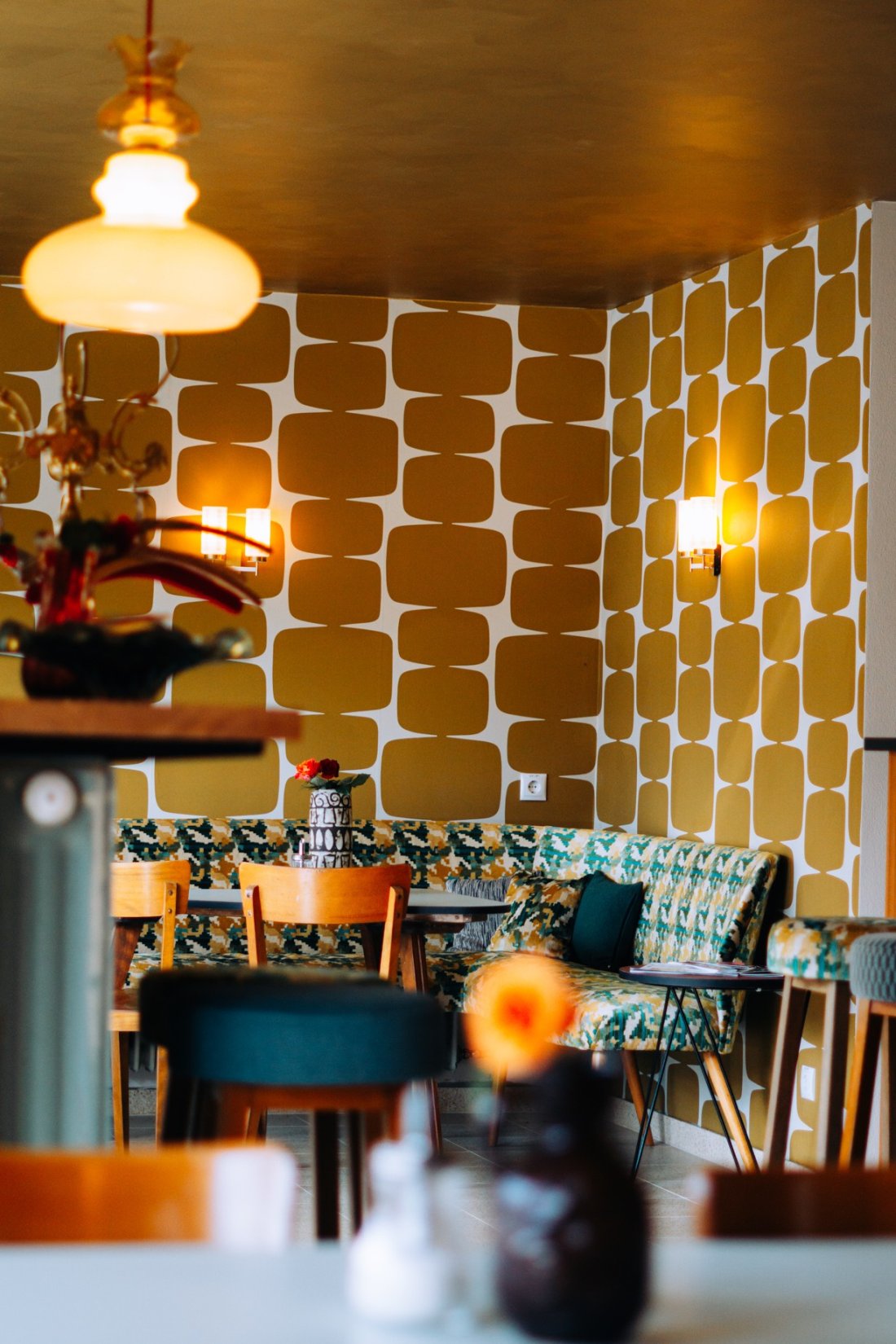 Stadscafe met okergeel retrobehang en een gouden plafond, door cestsjoukje