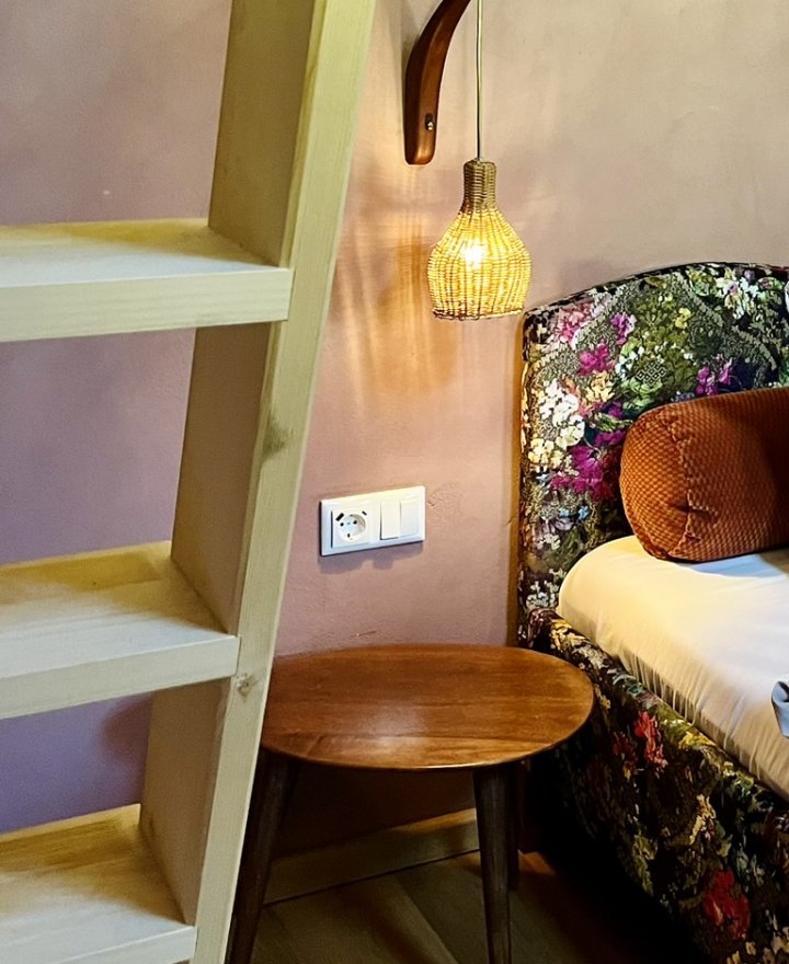 Rieten hanglamp boven een bijzettafel in een hotelkamer, boutique hotel interieur door cestsjoukje