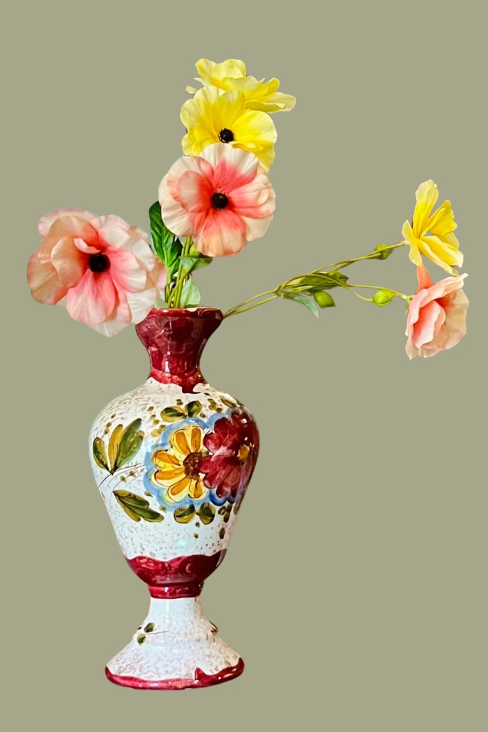 Handbeschilderde vaas met pastelbloemen in geel, perzik en roze als kleurdetail in een sfeervol hospitality interieur