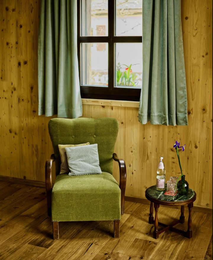 Hotelkamer met groene fauteuil in de raamhoek, door cestsjoukje