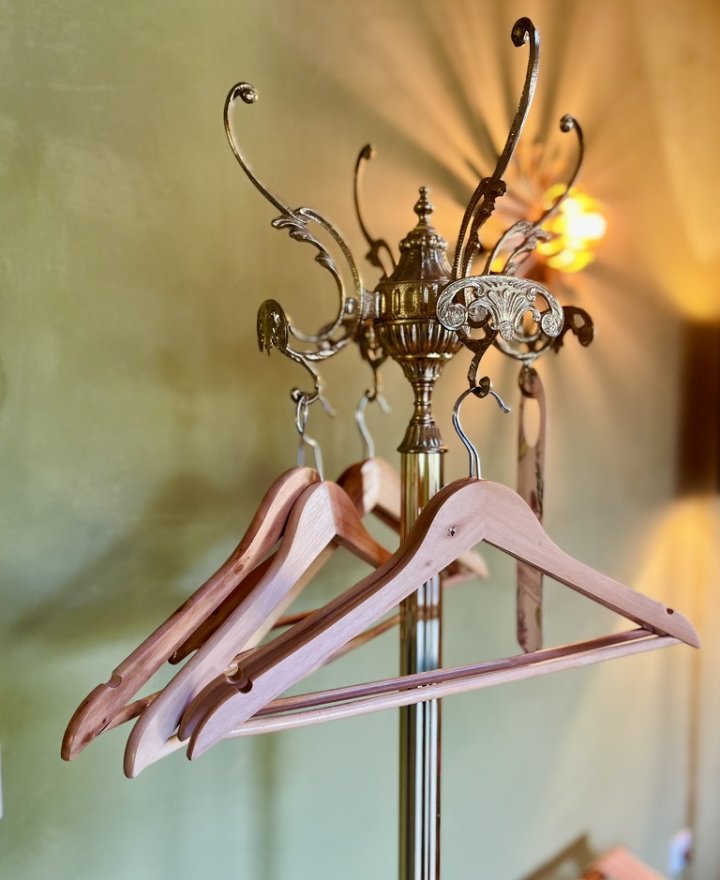 Messing kapstok met houten kledinghangers in een hotelkamer, hotelinterieur door cestsjoukje